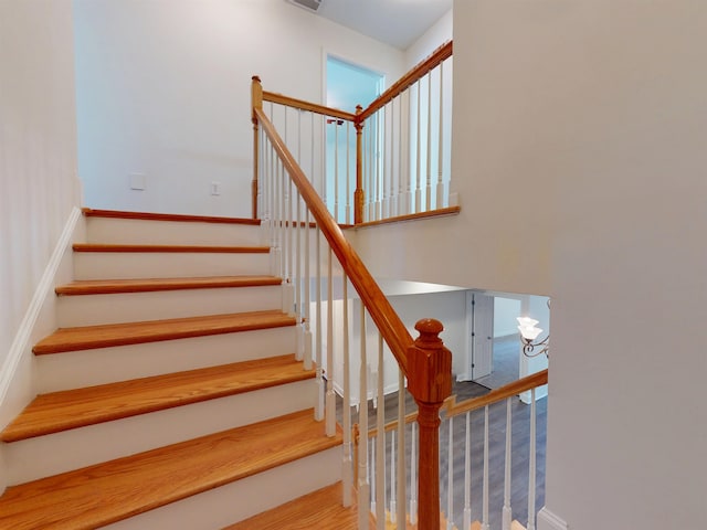 staircase with baseboards and wood finished floors