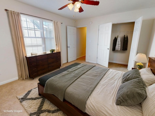 bedroom featuring baseboards, light colored carpet, ceiling fan, and a closet