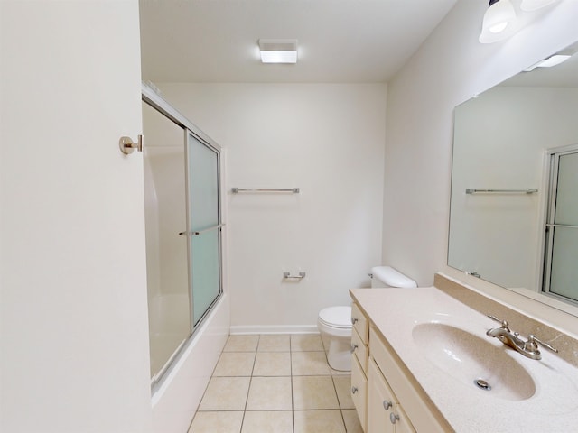bathroom featuring vanity, toilet, baseboards, tile patterned floors, and enclosed tub / shower combo