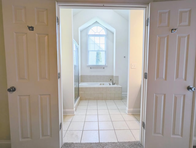 full bathroom with baseboards, tile patterned flooring, a bath, and a shower stall