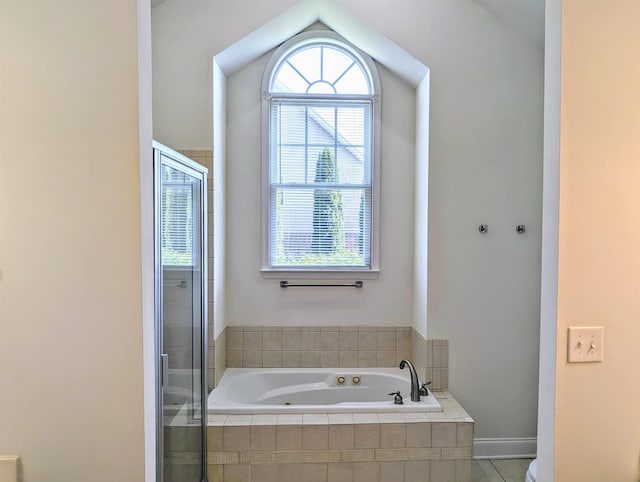 full bath with a jetted tub, baseboards, lofted ceiling, and a shower stall