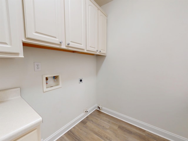 washroom with hookup for a gas dryer, hookup for a washing machine, cabinet space, light wood finished floors, and hookup for an electric dryer