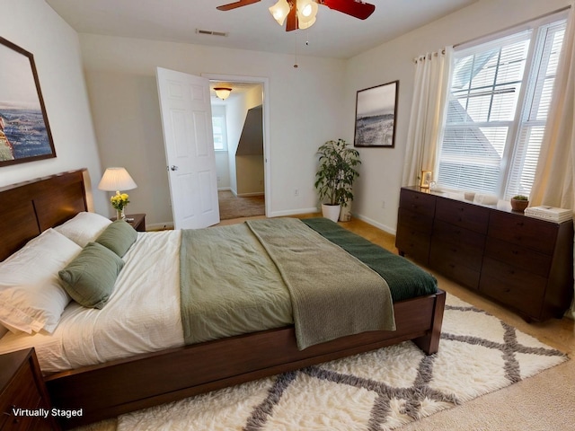bedroom with carpet floors, baseboards, ceiling fan, and visible vents