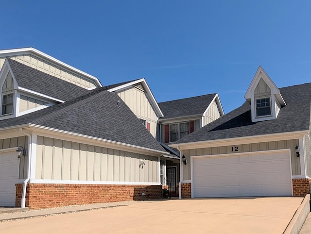 craftsman-style home with roof with shingles, board and batten siding, and brick siding