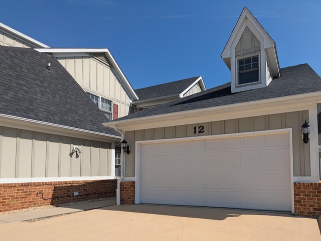 view of home's exterior with board and batten siding, brick siding, and a garage