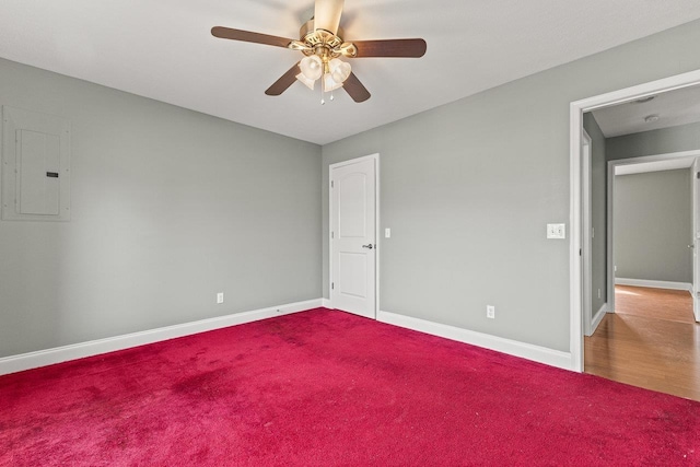 unfurnished bedroom with a ceiling fan, electric panel, baseboards, and carpet flooring