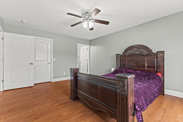 bedroom with ceiling fan, baseboards, and wood finished floors