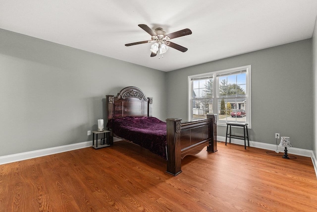 bedroom featuring ceiling fan, wood finished floors, and baseboards