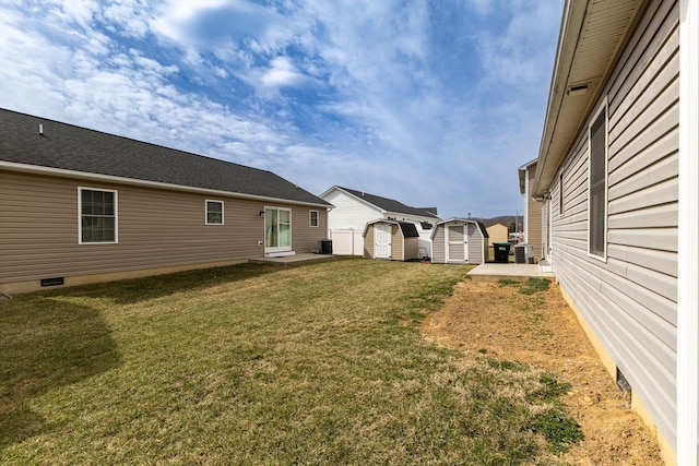 view of yard featuring an outbuilding, a storage shed, and central AC unit