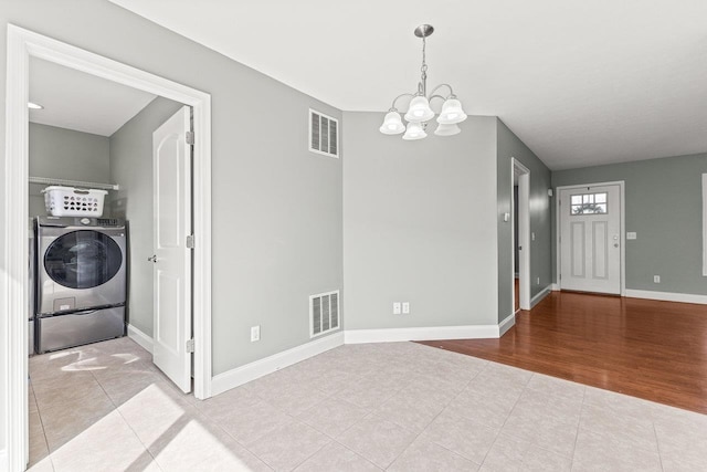 interior space with washer / clothes dryer, visible vents, an inviting chandelier, and laundry area