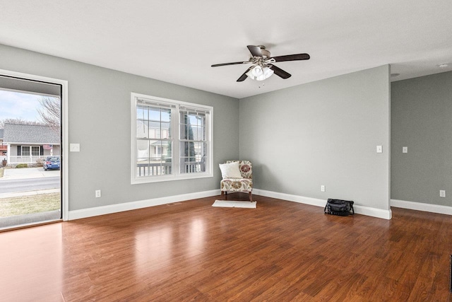 unfurnished room featuring a healthy amount of sunlight, baseboards, and wood finished floors