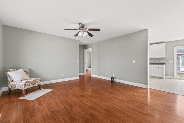 unfurnished room with light wood-style floors, baseboards, and a ceiling fan