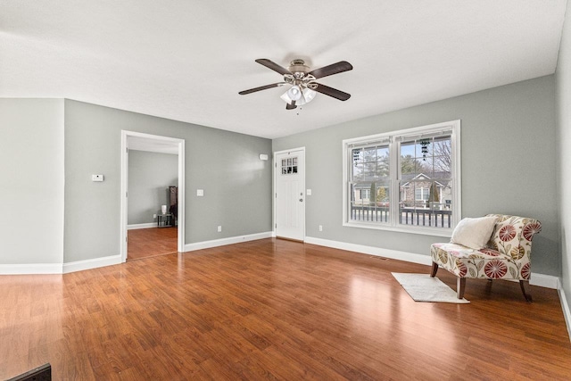 unfurnished room with ceiling fan, wood finished floors, and baseboards