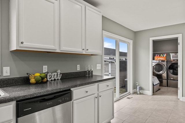 kitchen featuring dark countertops, white cabinetry, stainless steel dishwasher, and separate washer and dryer