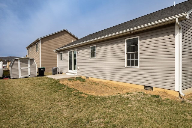 rear view of property featuring a storage shed, a lawn, crawl space, cooling unit, and an outdoor structure