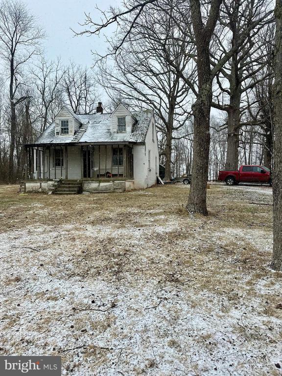 view of front facade featuring covered porch and a chimney