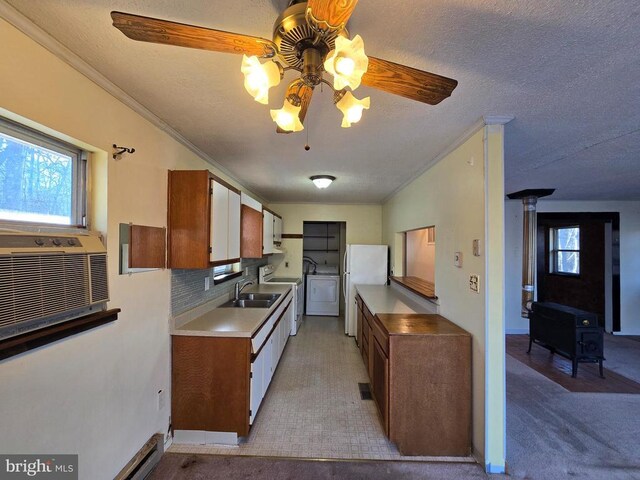 kitchen with backsplash, white refrigerator, ornamental molding, washer / dryer, and a wood stove