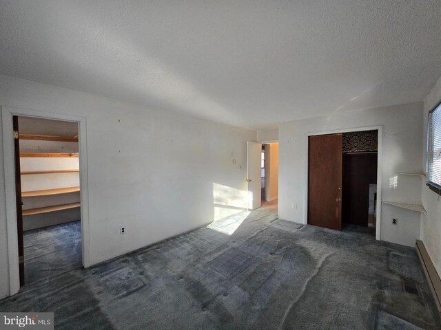 carpeted spare room featuring a textured ceiling