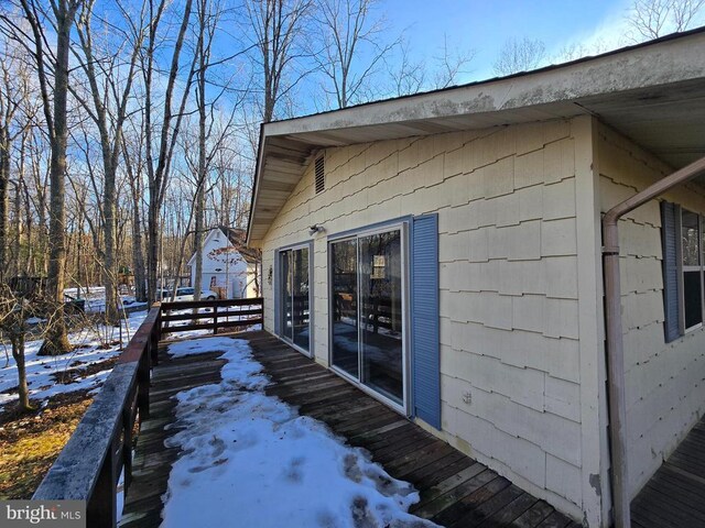 view of snow covered exterior featuring a wooden deck