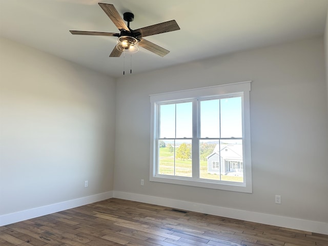 empty room with ceiling fan and dark hardwood / wood-style flooring