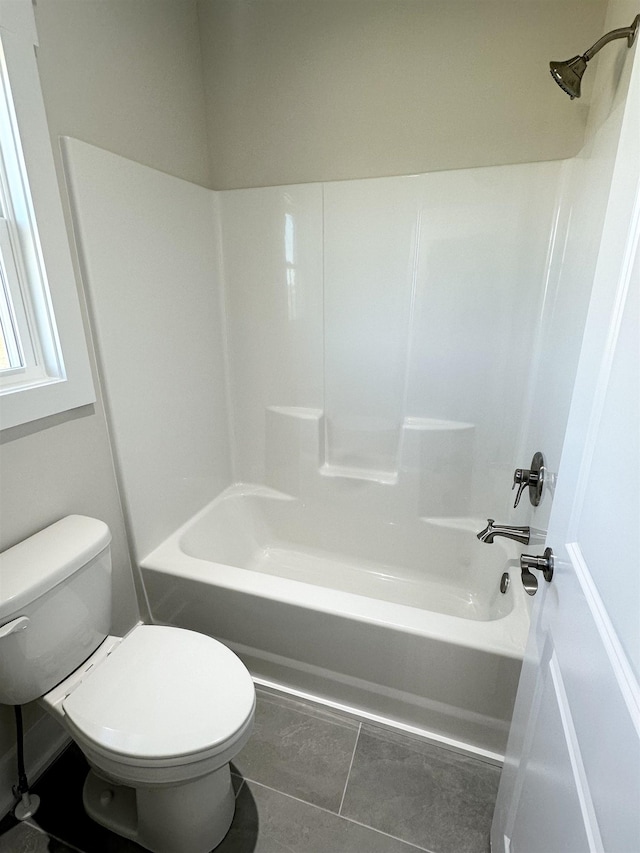 bathroom with shower / washtub combination, toilet, and tile patterned flooring