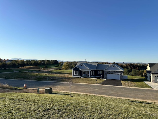 ranch-style house featuring a rural view, a garage, and a front lawn