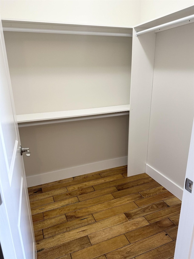 spacious closet with dark hardwood / wood-style flooring