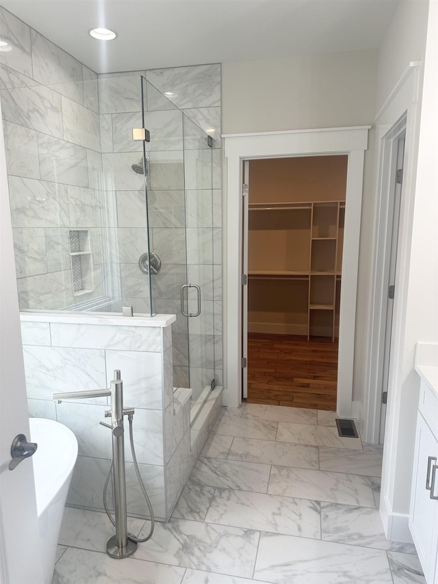 bathroom with shower with separate bathtub and vanity