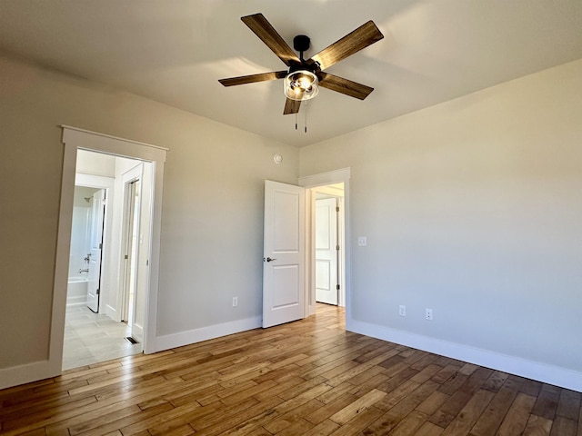 unfurnished bedroom with ensuite bath, light hardwood / wood-style flooring, and ceiling fan