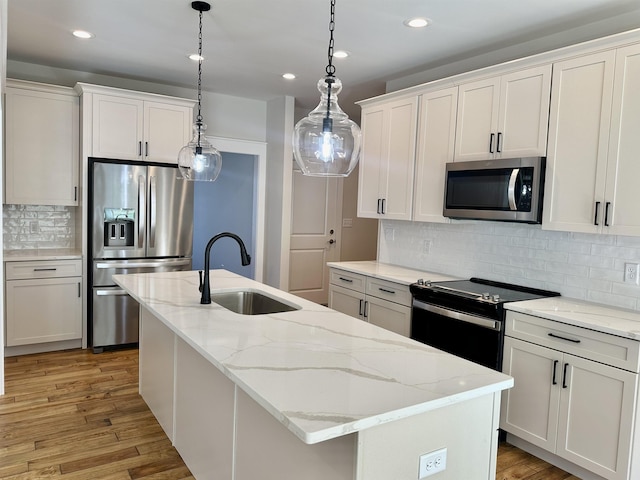 kitchen featuring a kitchen island with sink, sink, white cabinetry, and stainless steel appliances