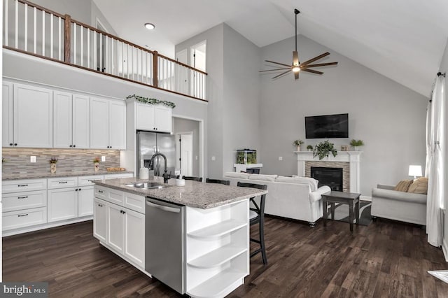 kitchen with dark wood-style floors, a ceiling fan, open shelves, appliances with stainless steel finishes, and open floor plan