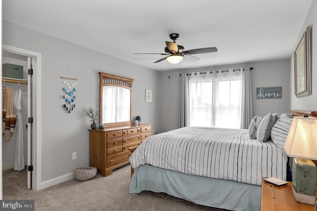 bedroom with a ceiling fan, a closet, carpet floors, baseboards, and a spacious closet