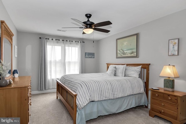 bedroom with visible vents, baseboards, light colored carpet, and ceiling fan