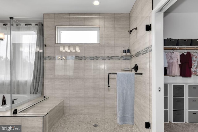 bathroom with a stall shower and a spacious closet