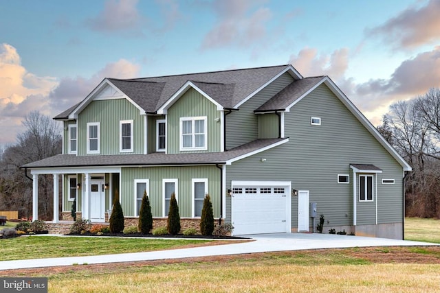 view of front of home featuring board and batten siding, a shingled roof, a front yard, driveway, and an attached garage