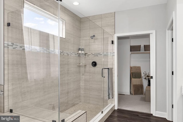 bathroom with a shower stall, ensuite bath, and wood finished floors