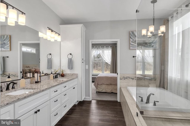 bathroom featuring double vanity, a notable chandelier, ensuite bath, and a sink