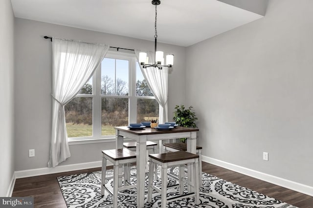 dining room with baseboards, an inviting chandelier, and wood finished floors