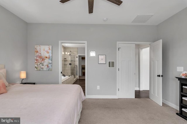 carpeted bedroom with visible vents, a ceiling fan, ensuite bathroom, and baseboards