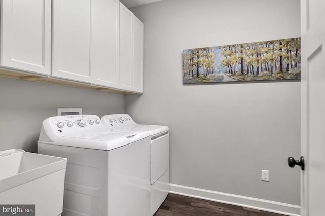 washroom with dark wood-type flooring, a sink, cabinet space, separate washer and dryer, and baseboards