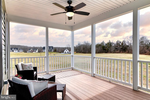 deck at dusk featuring a lawn and a ceiling fan