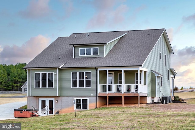 back of property with french doors, central AC, a yard, and roof with shingles