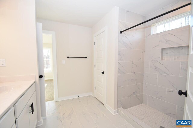 bathroom featuring vanity and tiled shower