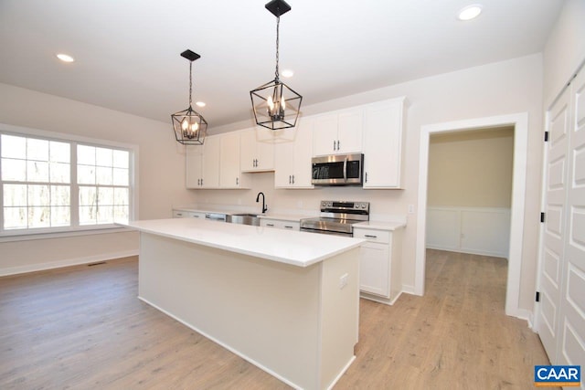 kitchen featuring white cabinetry, stainless steel appliances, and a kitchen island