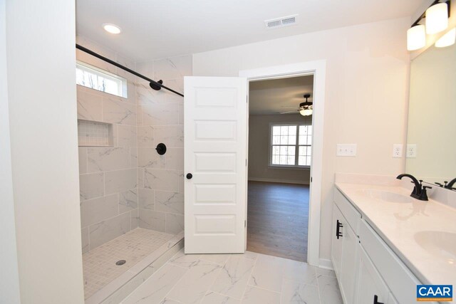 bathroom with vanity and a tile shower