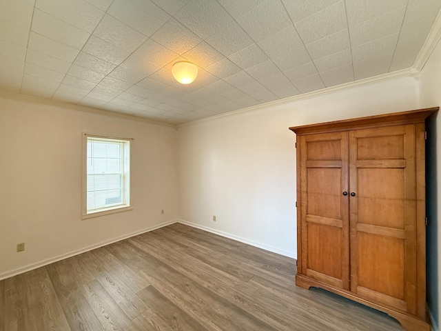 spare room featuring crown molding and hardwood / wood-style floors