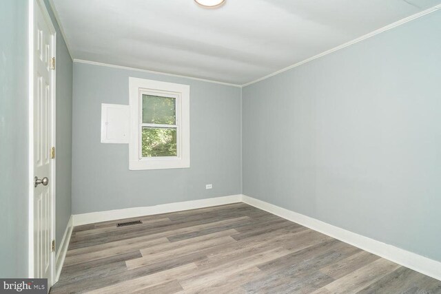 empty room featuring crown molding and light wood-type flooring