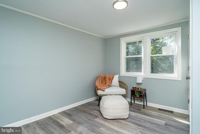 living area featuring ornamental molding and hardwood / wood-style floors