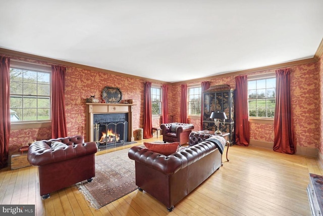 living room with a fireplace with flush hearth, light wood-type flooring, baseboards, and wallpapered walls