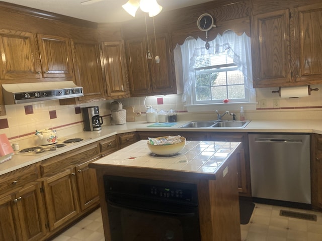 kitchen with oven, a sink, exhaust hood, stainless steel dishwasher, and light floors